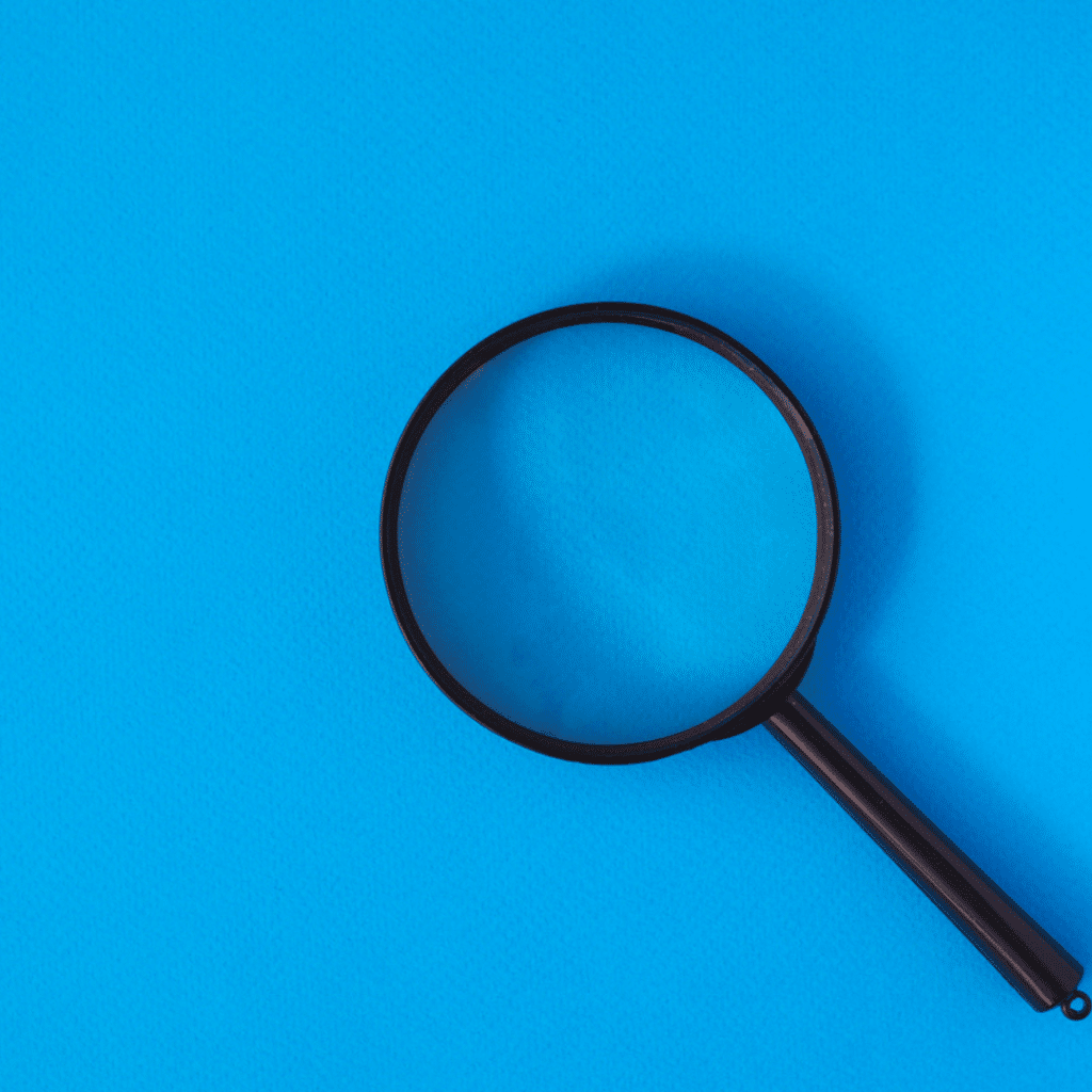 Magnifying glass laid against blue background