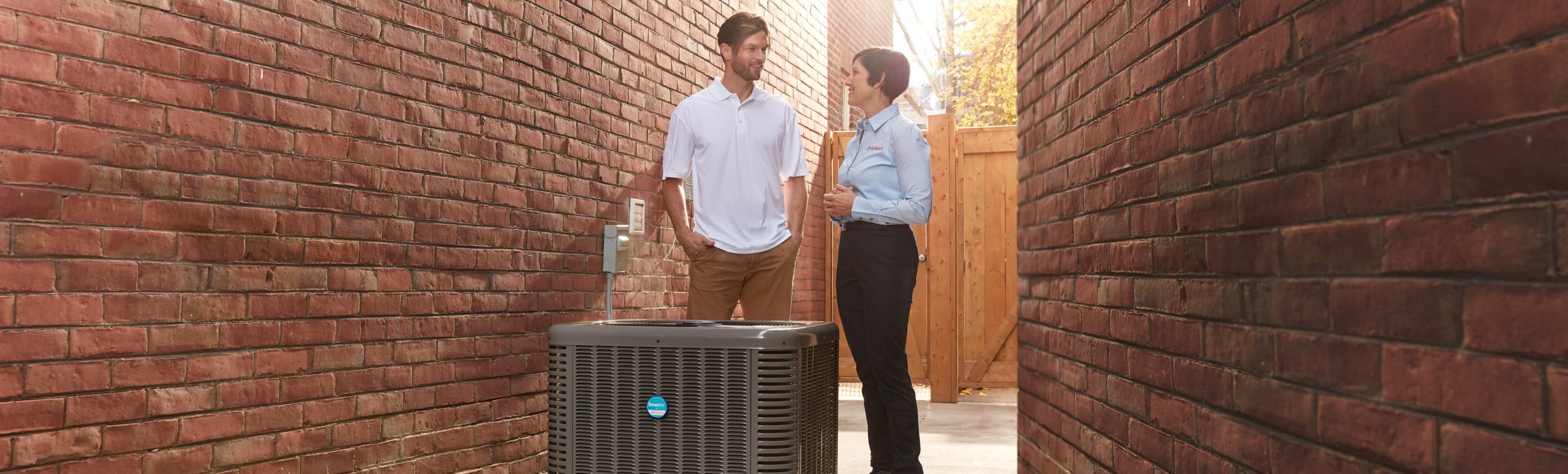 Reliance service worker and client conversing next to the AC
