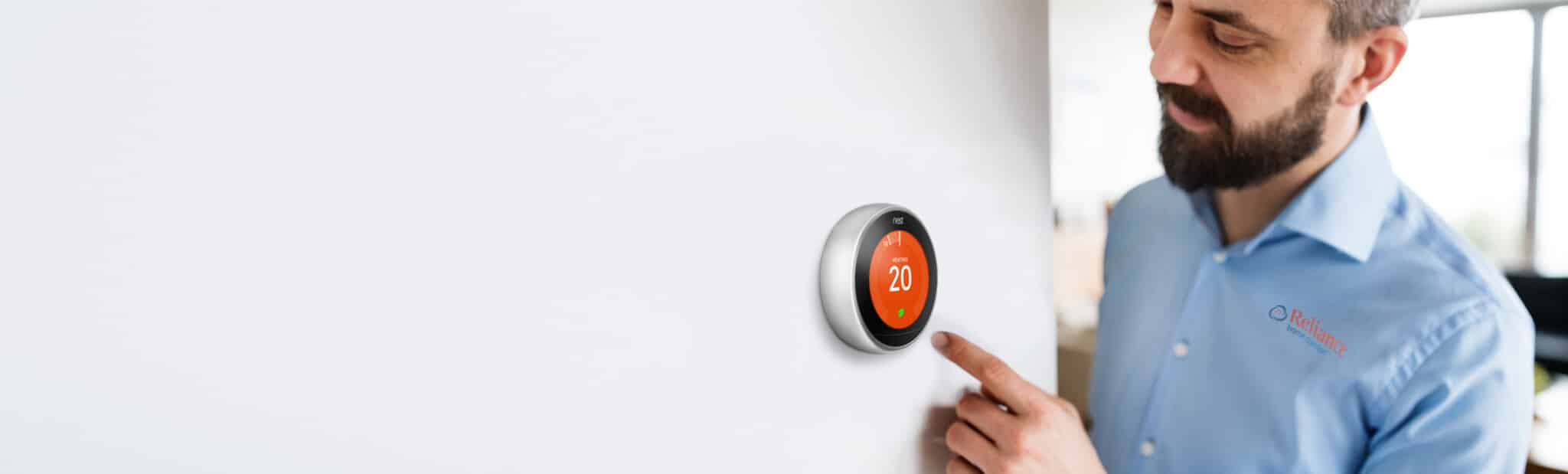 close up of a reliance worker using a smart thermostat