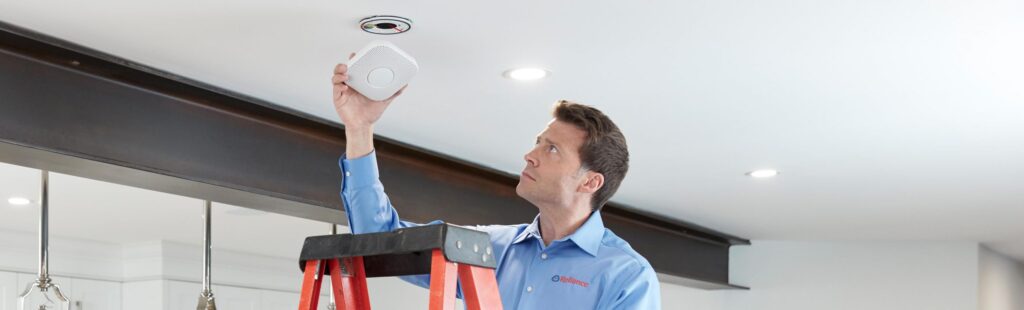 Reliance worker changing smoke detector