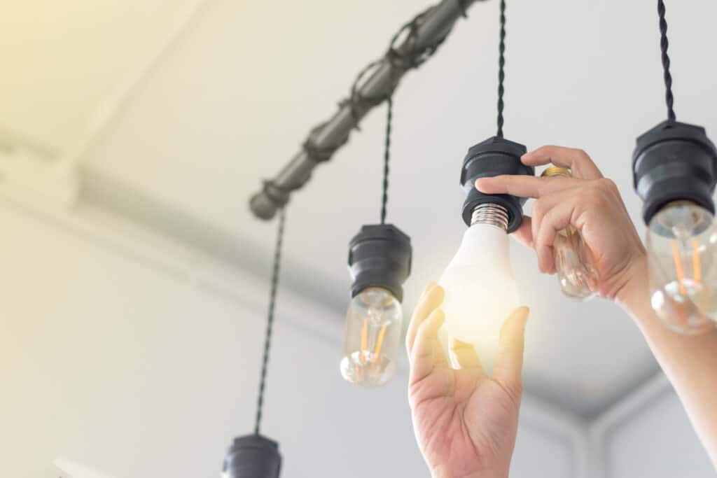 LED light Power saving concept. man changing compact-fluorescent (CFL) bulbs with new bulb.