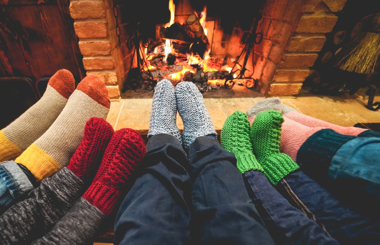 Legs view of family wearing warm socks in front of fireplace