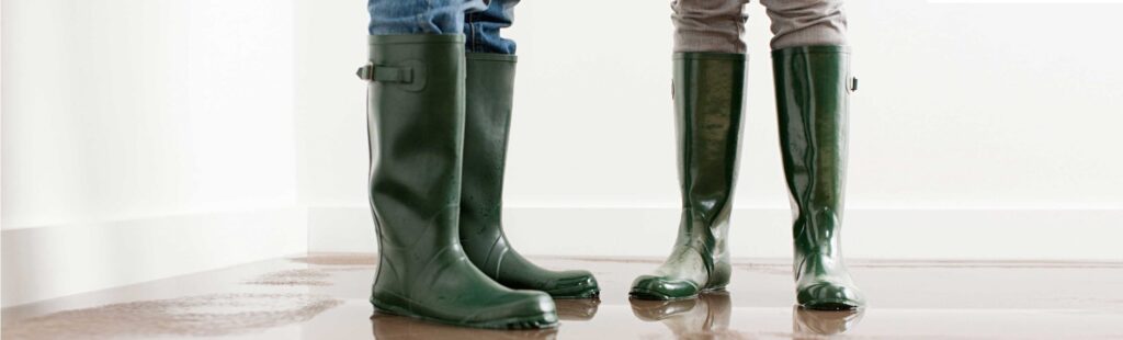 People wearing rubber boots in a house with flooded floors