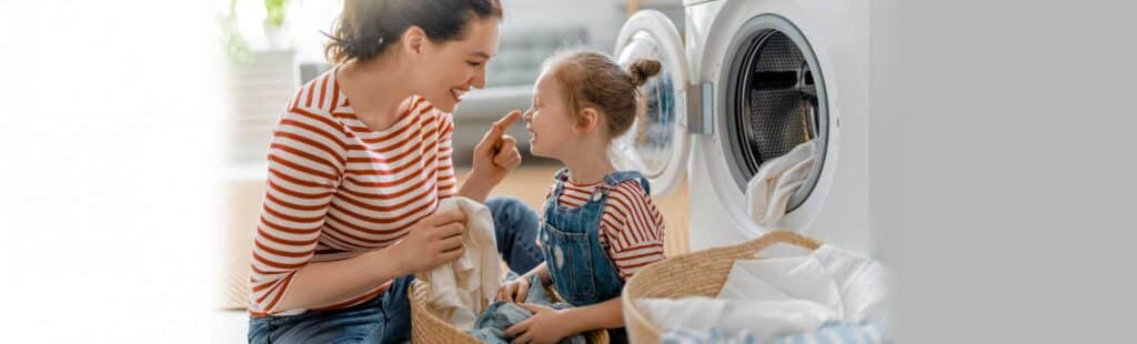 Mother and daughter smiling at each other while taking out the laundry