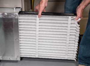 Image of a furnace filter being removed from the filter 