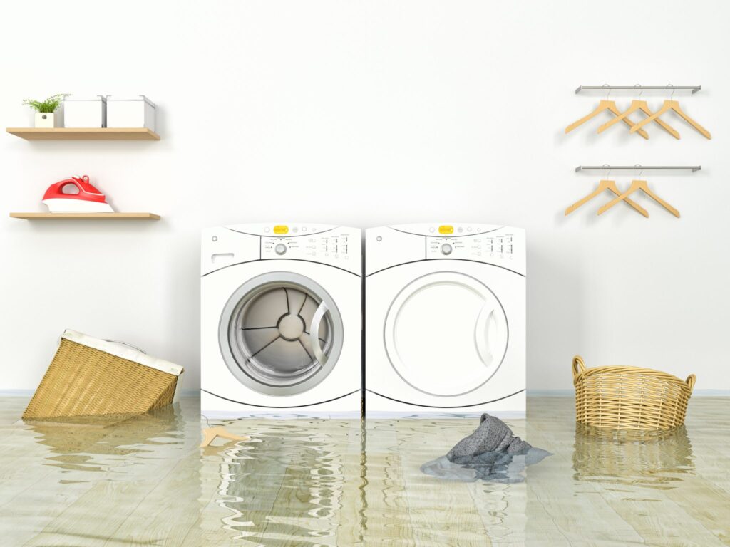 Flooded laundry room with baskets, a hanger, and piece of clothing floating around