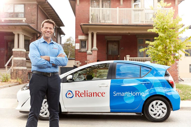 Technician with reliance branded car behind