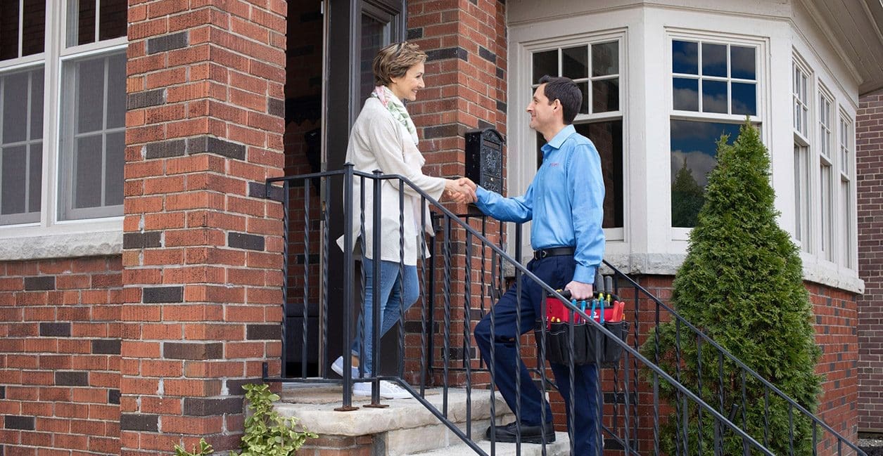 technician shaking hands with customer on front porch