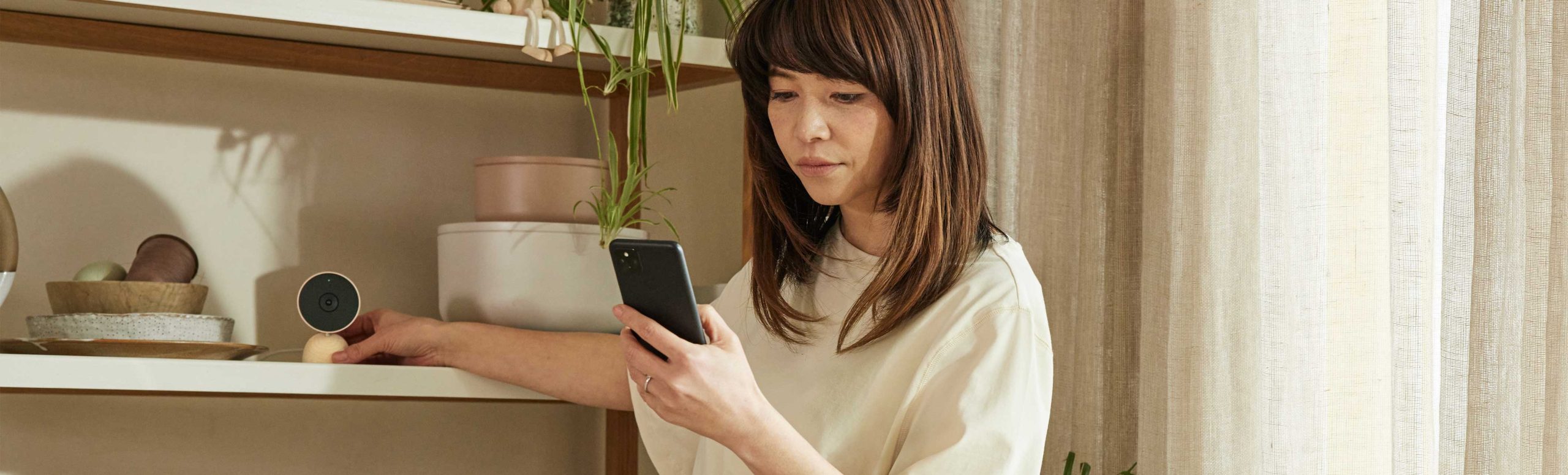 Woman looking at smart phone in configuring google nest at home