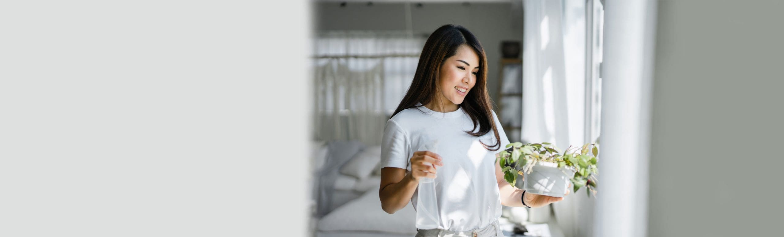 Woman looking at healthy plant by the kitchen window
