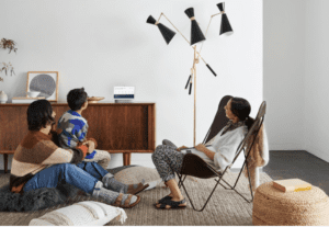 family in living room interacting with a Google Nest Hub