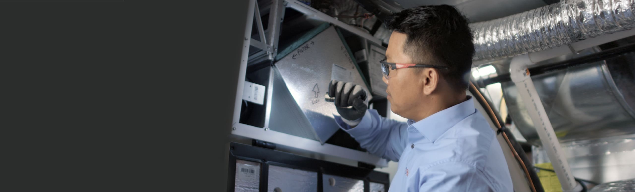 Reliance technician inspecting a furnace with a flashlight