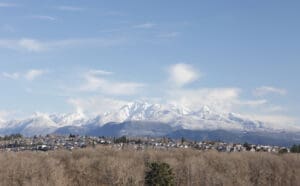 The Coast Mountains in the Pacific Coast Ranges stand near Metro Vancouver. Foreground shows the suburban cities of Coquitlam and Port Coquitlam near the Fraser River. Winter morning.