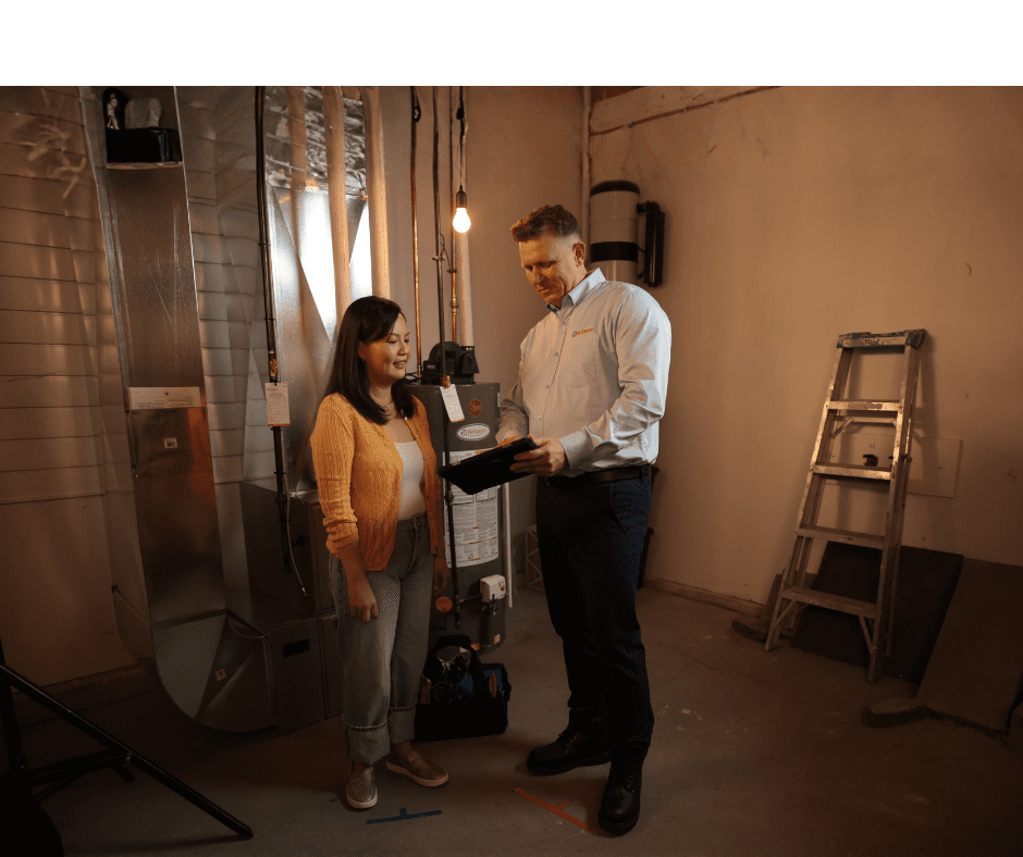 a Reliance water heater technician talks to a customer beside her water heater