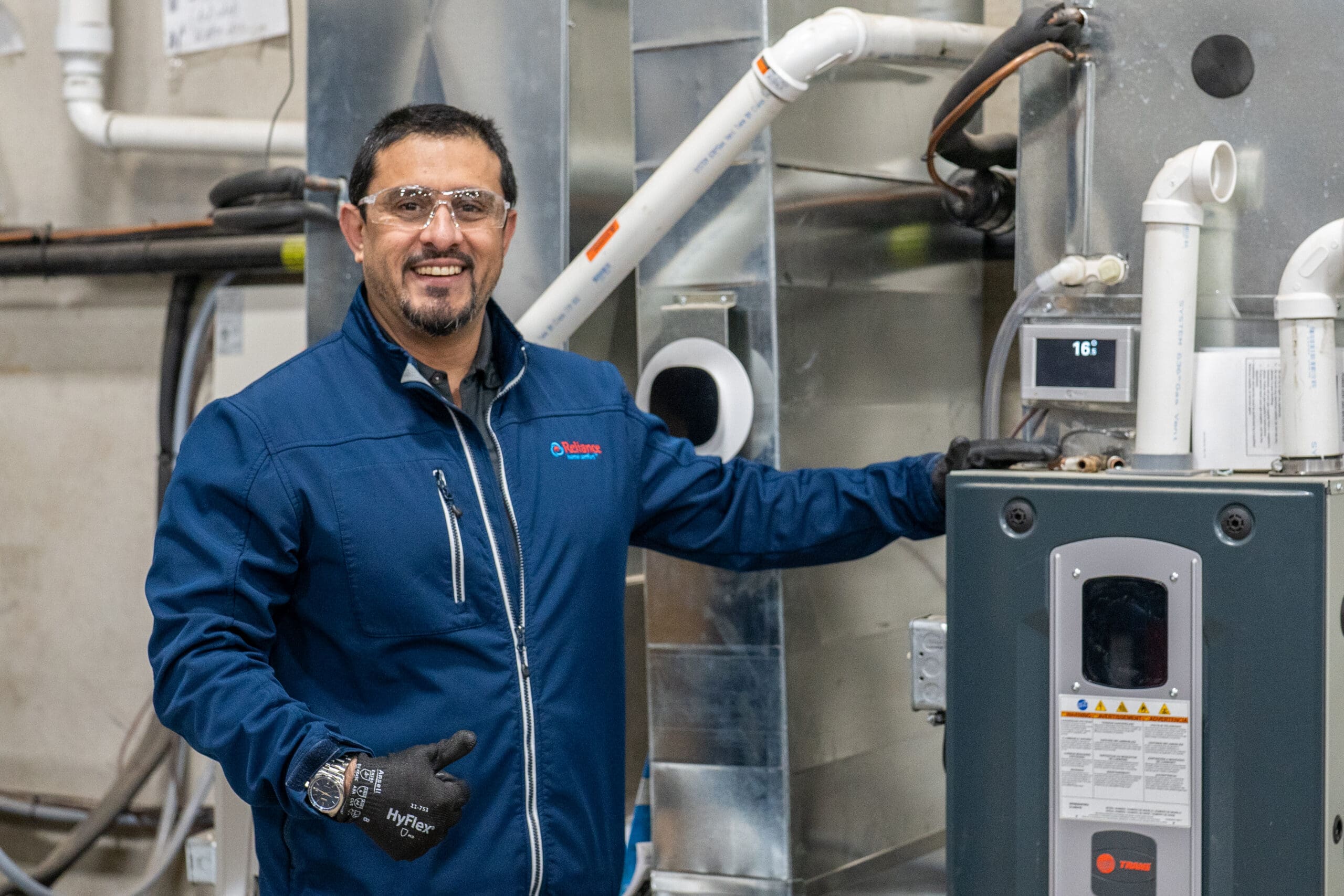 Reliance Home Comfort Advisor, Majid Khan in our warehouse with a furnace
